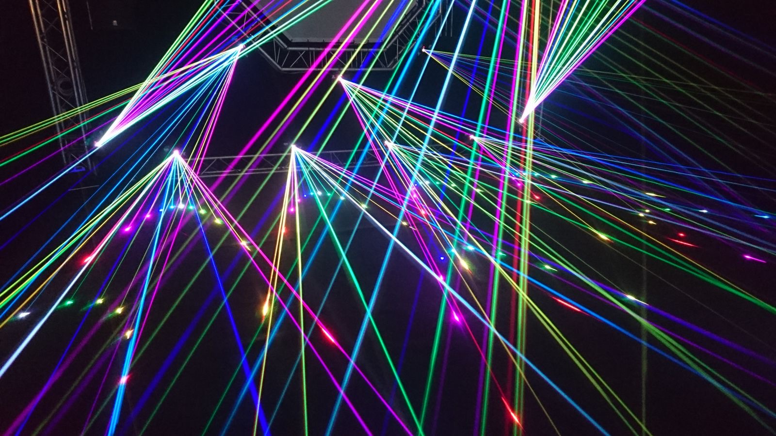 Multicolored laser beams crossing a dark room
